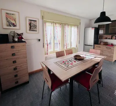 a kitchen with a table and chairs and a refrigerator at Casa di Charme sul Civetta Dolomiti in Caprile