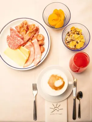 a table topped with plates of food and bowls of fruit at Hotel Sella Ronda Serenella - A 50 mt dalle piste da sci in Campitello di Fassa