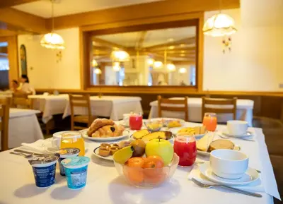a table with breakfast foods on a table in a restaurant at Hotel Sella Ronda Serenella - A 50 mt dalle piste da sci in Campitello di Fassa