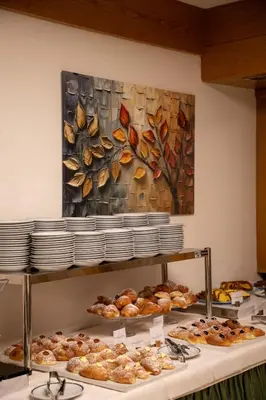 a buffet with pastries and a painting on the wall at Hotel Sella Ronda Serenella - A 50 mt dalle piste da sci in Campitello di Fassa