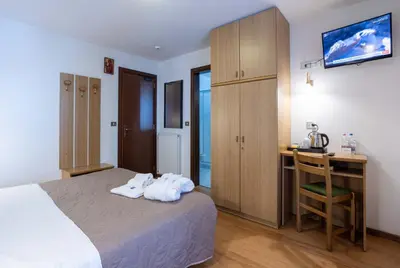 a hotel room with a bed and a desk and a desk at Hotel Sella Ronda Serenella - A 50 mt dalle piste da sci in Campitello di Fassa