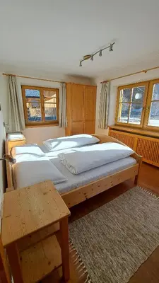 a bedroom with two large beds and a table at Haus am Park in Rasùn di Sotto
