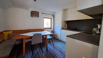 a small kitchen with a table and a counter top at Haus am Park in Rasùn di Sotto
