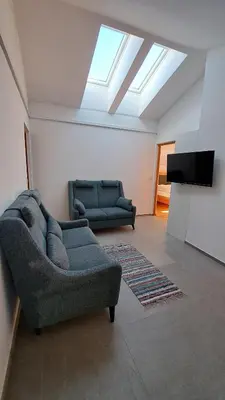 a living room with two couches and a television at Haus am Park in Rasùn di Sotto