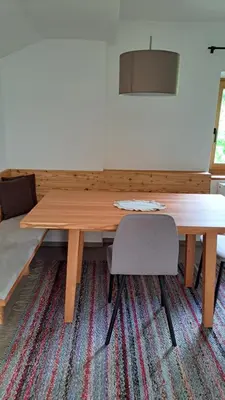 a wooden table and two chairs in a room at Haus am Park in Rasùn di Sotto