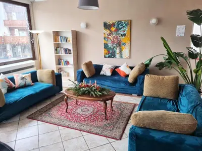 a living room with blue couches and a coffee table at Excelsior Hotel Cimone LowCost in San Martino di Castrozza