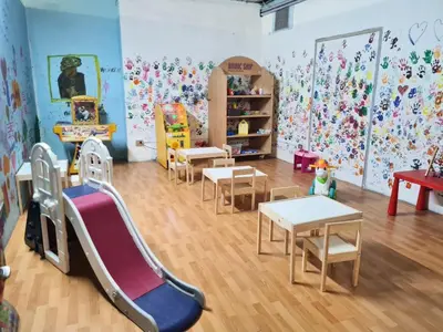 a room with tables and chairs and a play area at Excelsior Hotel Cimone LowCost in San Martino di Castrozza