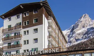 a hotel in front of a mountain at Excelsior Hotel Cimone LowCost in San Martino di Castrozza