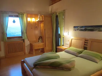 a bedroom with a bed with green pillows and a window at CHALET LEE's HERZNESCHTL in Rodengo