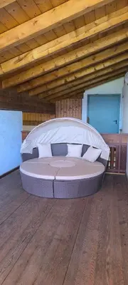 a large bed in a room with a wooden ceiling at CHALET LEE's HERZNESCHTL in Rodengo