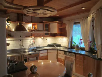 a kitchen with wooden cabinets and a table in it at CHALET LEE's HERZNESCHTL in Rodengo