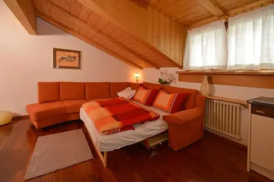 a living room with a bed and a couch at Apartments Rezia in Ortisei