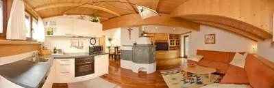 a large kitchen and living room with a couch at Apartments Rezia in Ortisei