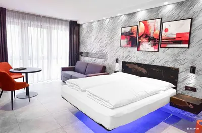 a bedroom with a bed and a chair and a table at ADV HOME - Exclusive Rooms in Bolzano