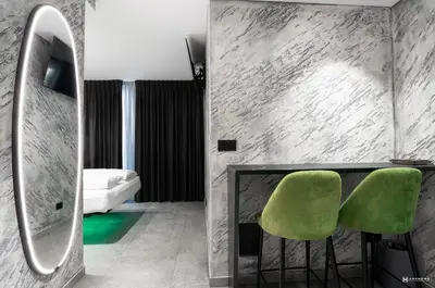 a room with two green chairs and a mirror at ADV HOME - Exclusive Rooms in Bolzano
