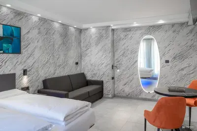 a bedroom with a bed and a table and a mirror at ADV HOME - Exclusive Rooms in Bolzano