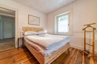 a large bed in a room with a window at La Casa dei Botiri in Rocca Pietore