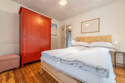 a bedroom with a large bed and a red cabinet at La Casa dei Botiri in Rocca Pietore