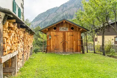 a wooden shed with a sign on the door at La Casa dei Botiri in Rocca Pietore