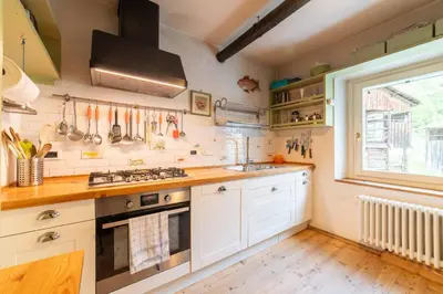 a kitchen with white cabinets and a window at La Casa dei Botiri in Rocca Pietore