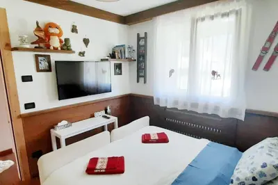 a bedroom with two beds and a tv and a window at 3BDRM Luxury Magic Flat near Cortina with Garage in Villanova