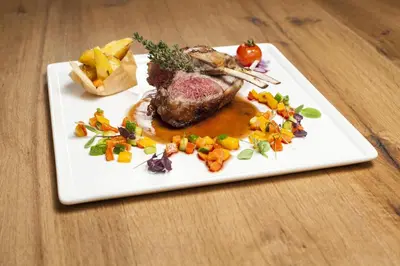a plate of food with meat and vegetables on a table at Dorfhotel Beludei in Santa Cristina in Val Gardena