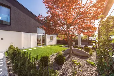 a tree in the courtyard of a house at Chalet Merangardenvilla in Merano