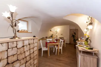 a kitchen and dining room with a stone wall at B&B Incanto in Cles