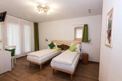two beds in a room with green curtains at B&B Incanto in Cles