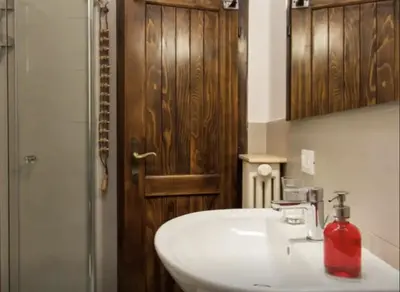 a bathroom with a white sink and a red soap dispenser at Casa Remo 3 by WelcHome in Chiapuzza
