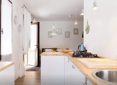 a white kitchen with a sink and a stove at Casa Remo 3 by WelcHome in Chiapuzza