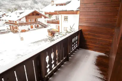 a balcony with a view of snow covered buildings at Verocai Studio by WelcHome in Cortina dʼAmpezzo