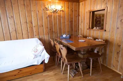 a bedroom with a table and a bed in a room at Verocai Studio by WelcHome in Cortina dʼAmpezzo