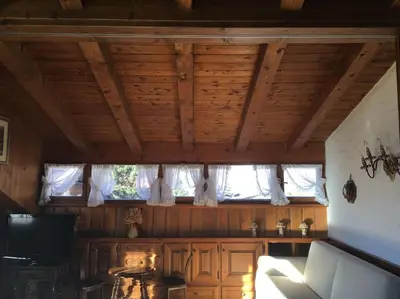 a living room with a couch and a window at Verocai Views by WelcHome in Cortina dʼAmpezzo