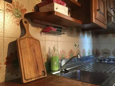 a kitchen counter with a sink and a cutting board at Verocai Views by WelcHome in Cortina dʼAmpezzo