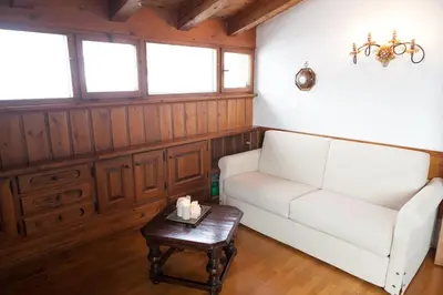 a living room with a white couch and a table at Verocai Views by WelcHome in Cortina dʼAmpezzo