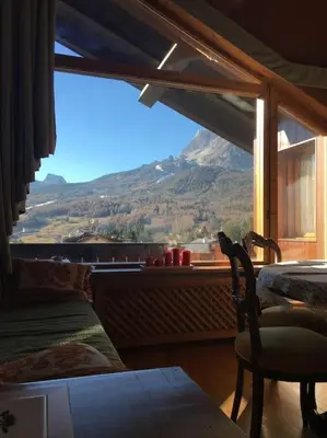 a room with a window with a view of a mountain at Verocai Views by WelcHome in Cortina dʼAmpezzo