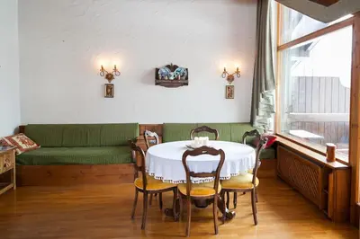 a dining room with a table and chairs and a couch at Verocai Views by WelcHome in Cortina dʼAmpezzo