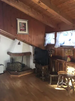 a living room with a television and a fireplace at Verocai Views by WelcHome in Cortina dʼAmpezzo