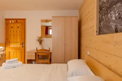 a bedroom with a bed and a wooden wall at Villa Maria in Falcade