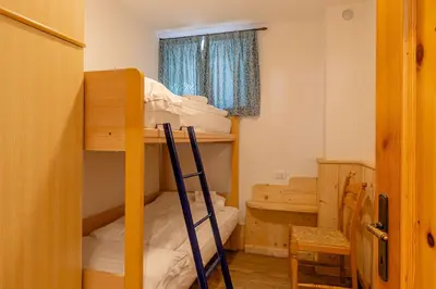 a room with two bunk beds and a ladder at Villa Maria in Falcade