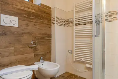 a bathroom with a toilet and a sink and a shower at Villa Maria in Falcade