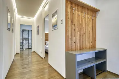 a hallway with a wooden accent wall and a blue desk at Apartment Heinz in Merano