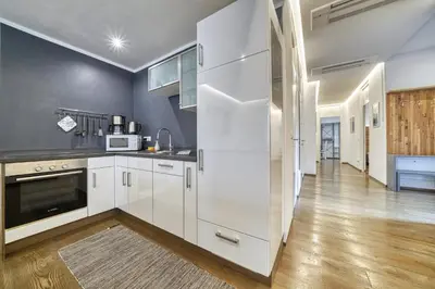 a kitchen with white cabinets and a large refrigerator at Apartment Heinz in Merano