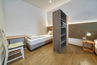 a small room with a bed and a desk at Apartment Heinz in Merano
