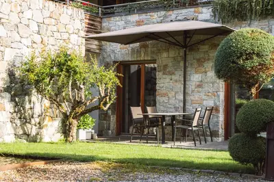 a patio with a table and chairs under an umbrella at Apartment Egghof im Weingut in Merano