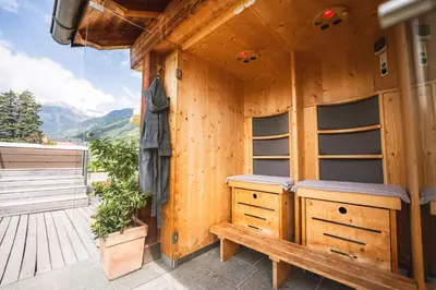 a wooden cabin with a bench on a deck at Apartment Egghof im Weingut in Merano