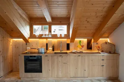 a kitchen with wooden cabinets and a stove at Cà Bianca delle Dolomiti in Cortina dʼAmpezzo