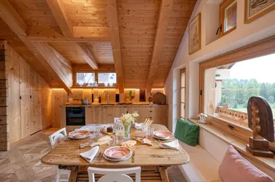 a dining room with a wooden table in a house at Cà Bianca delle Dolomiti in Cortina dʼAmpezzo