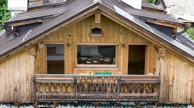 a wooden house with a balcony and a window at Cà Bianca delle Dolomiti in Cortina dʼAmpezzo